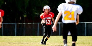 Youth football boy running the ball.