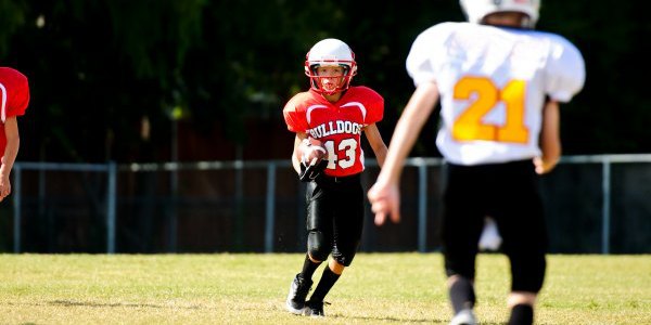 Youth football boy running the ball.